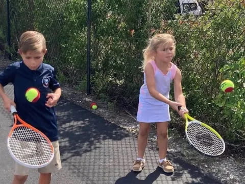 a couple of kids play tennis