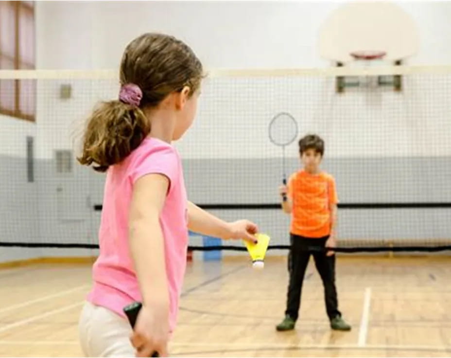 a couple of children playing tennis