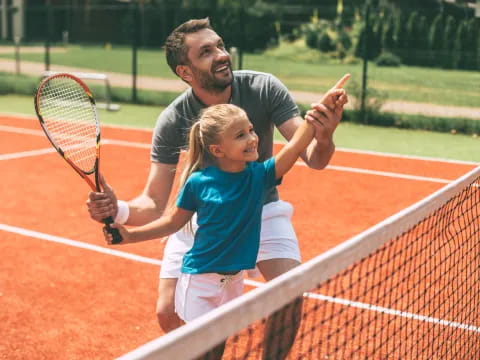 a person and a girl playing tennis