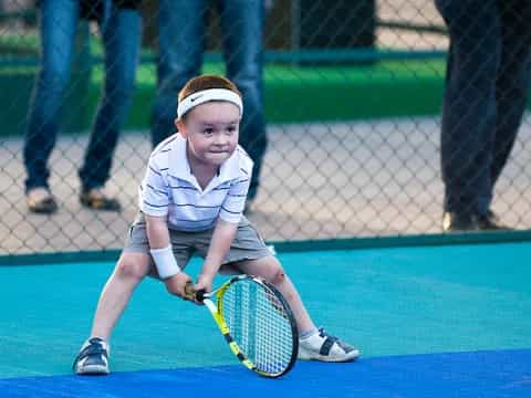 a young boy playing tennis