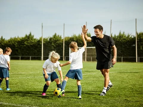 a person and kids playing football