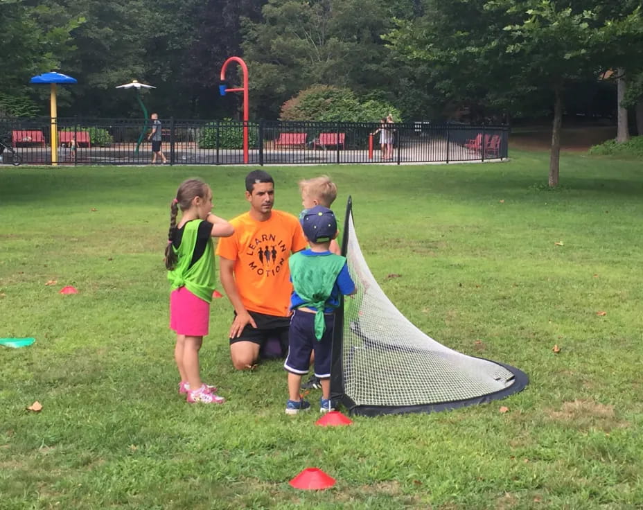 a group of kids playing with a kite in a park