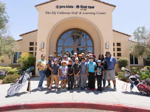 a group of people posing for a photo in front of a building