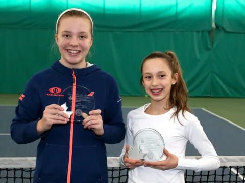 a couple of girls holding tennis rackets