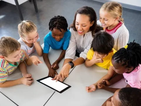 a group of children looking at a tablet