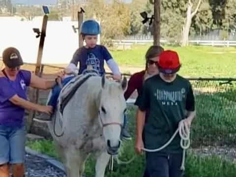 a group of people with a child on a horse