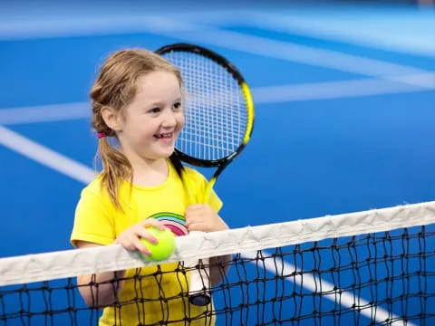 a little girl playing tennis