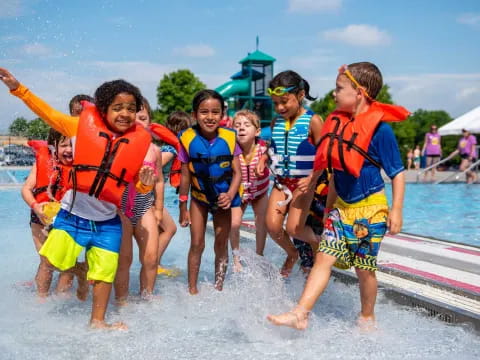 a group of people wearing life vests and standing in water