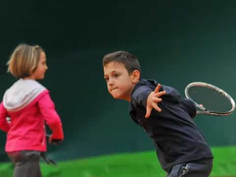 a boy and girl playing tennis