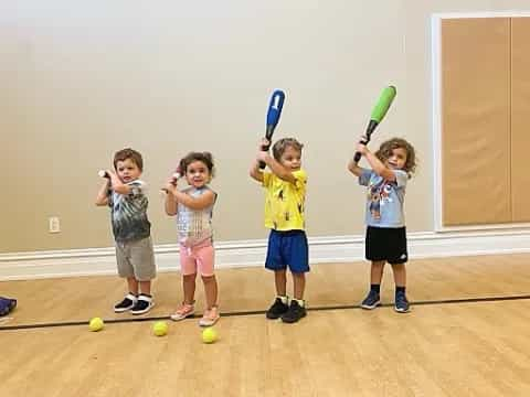 kids holding bats and balls