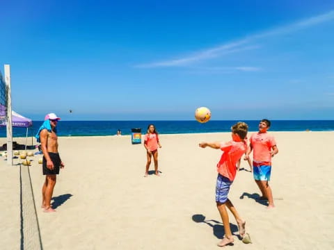 a group of people play volleyball on a beach