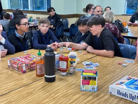 a group of people sitting at a table with food and drinks