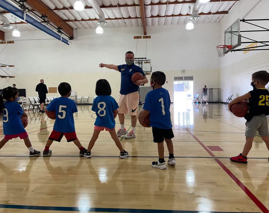 a person and a group of kids playing basketball