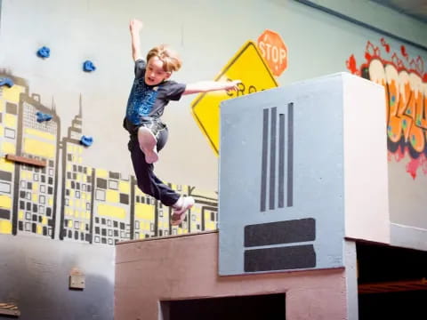 a young boy jumping off a ramp