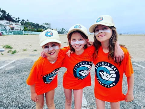 a group of children wearing matching t-shirts and hats