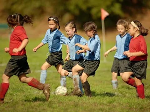 a group of girls compete over a football ball