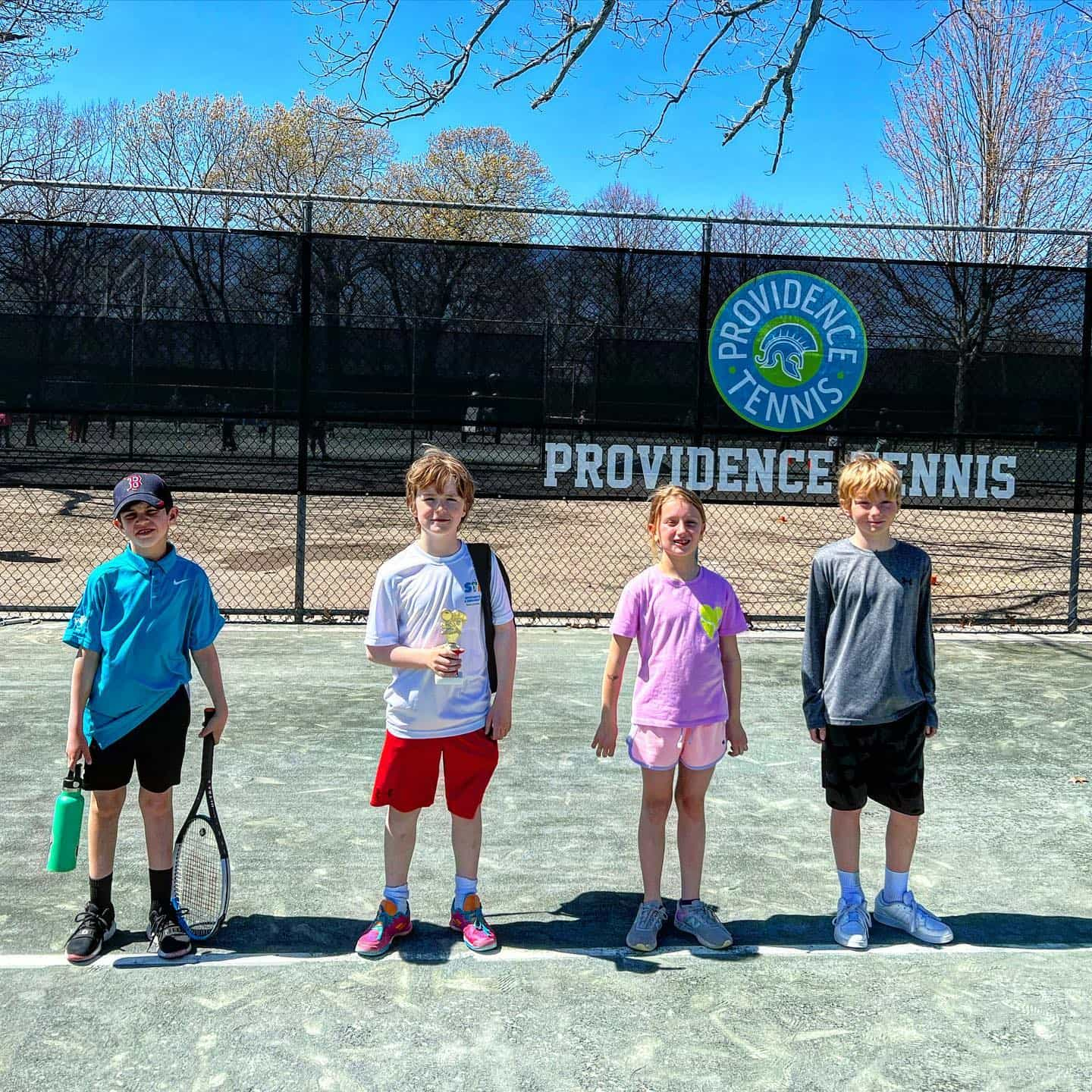 a group of kids holding tennis rackets