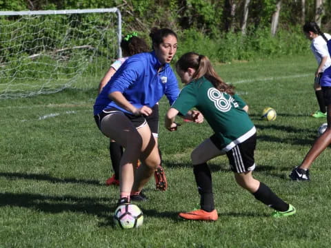 girls playing football on a field