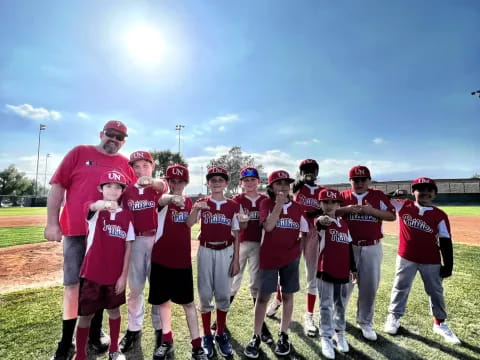 a group of people wearing matching red shirts and standing on a field