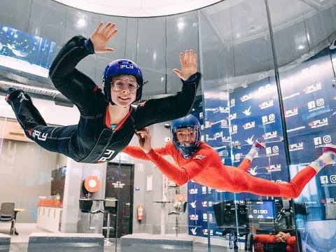 a man and woman wearing helmets and jumping in the air