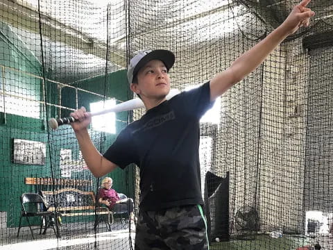 a boy swinging a baseball bat