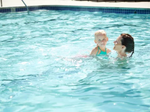 a person and a baby in a pool