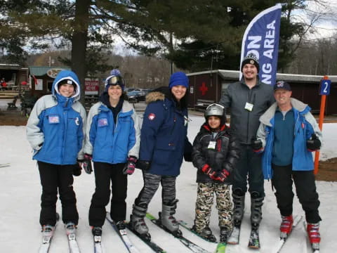 a group of people pose for a photo on snow skis