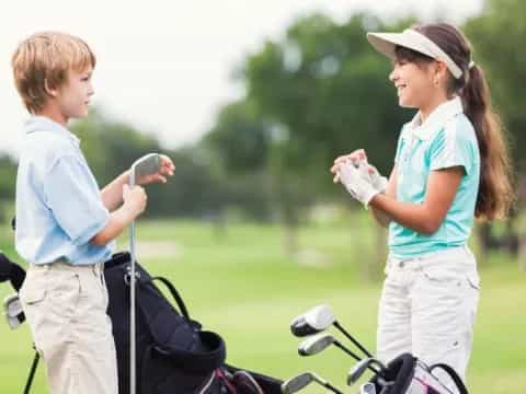 a person and a boy on a golf course