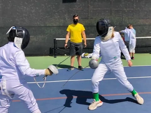 a couple of people in white uniforms playing a sport