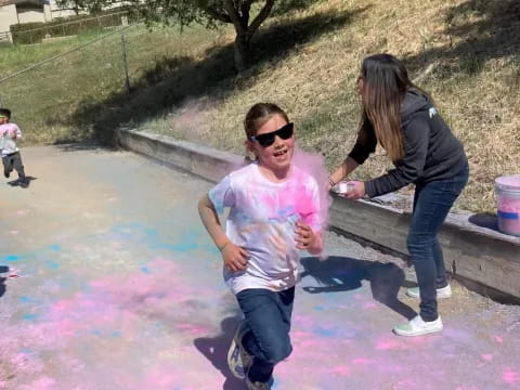 a person and a girl playing in a puddle of water