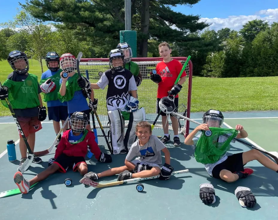 a group of people wearing helmets and holding sticks posing for the camera