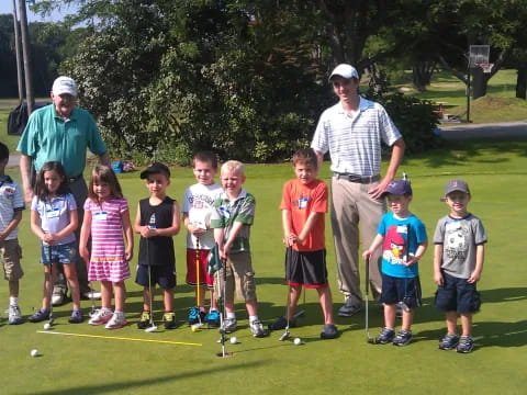 a group of people standing on a golf course