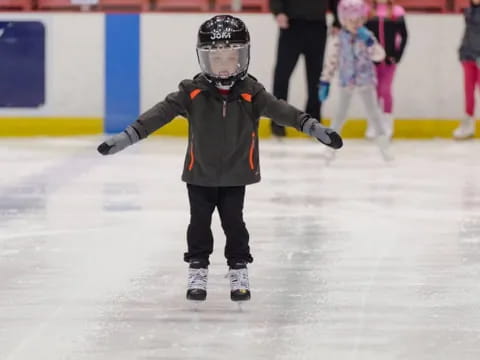 a boy wearing a helmet and ice skates