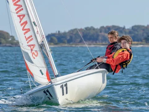 a couple of people on a sailboat in the water