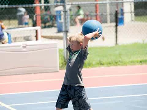 a boy holding a blue ball