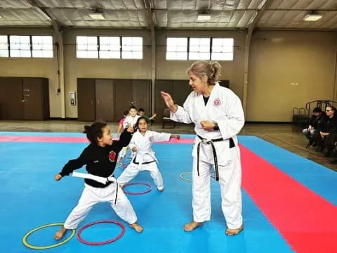 a person and a group of children in karate uniforms