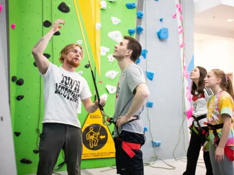 a group of people standing in a room with a green wall