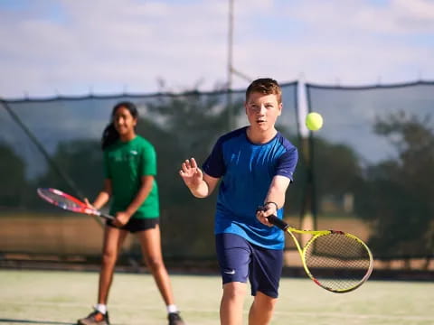 a couple of people play tennis