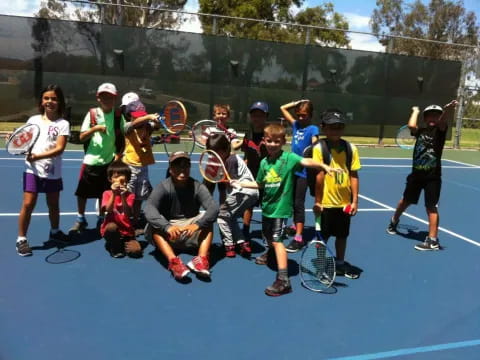 a group of kids holding tennis rackets