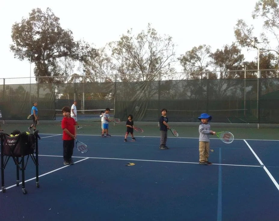 kids playing tennis on a court