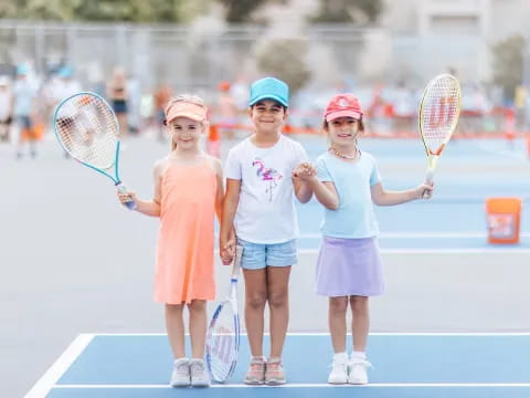 a group of girls holding tennis rackets