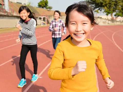 a group of children running on a track