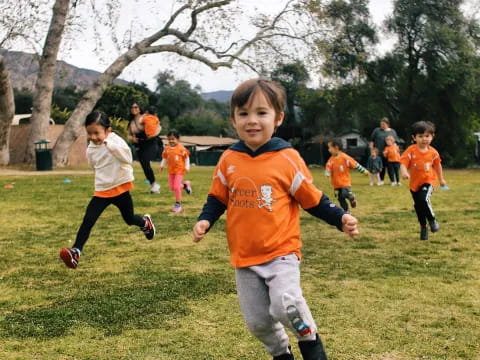 a group of kids running on a field