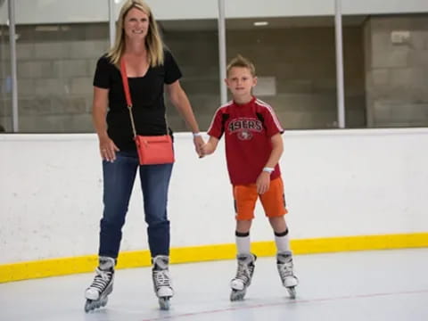 a person and a boy on an ice rink