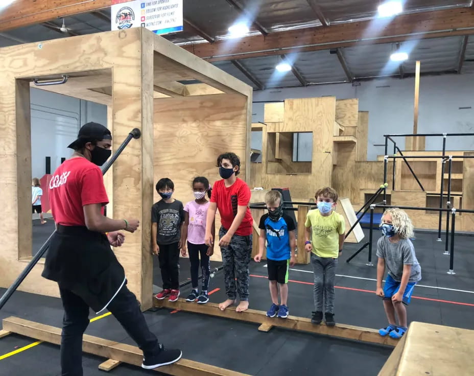 a man holding a sword in front of a group of kids