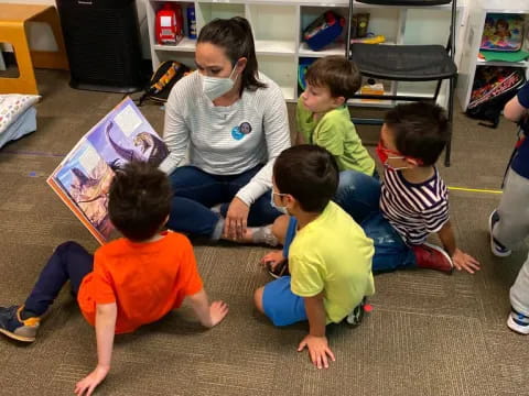 a person and several children sitting on the floor