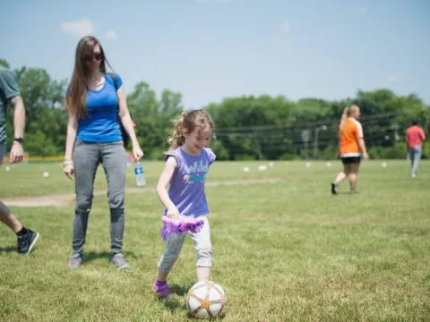 a person and a child playing with a football ball