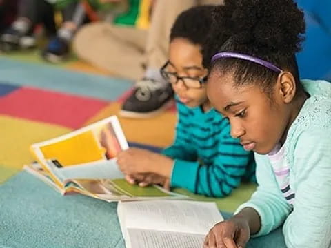 a young girl reading a book to a young girl