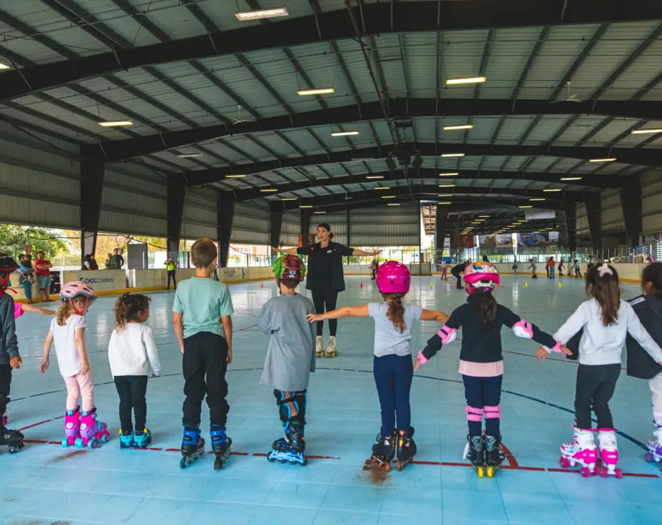 a group of kids wearing roller skates and helmets