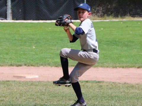 a young boy pitching a baseball